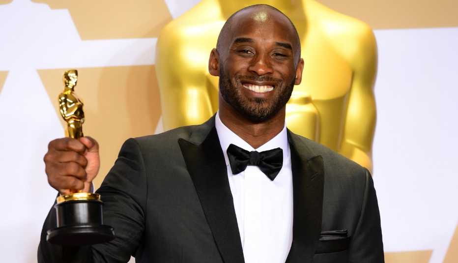 kobe bryant holding his academy award up and smiling in 2018