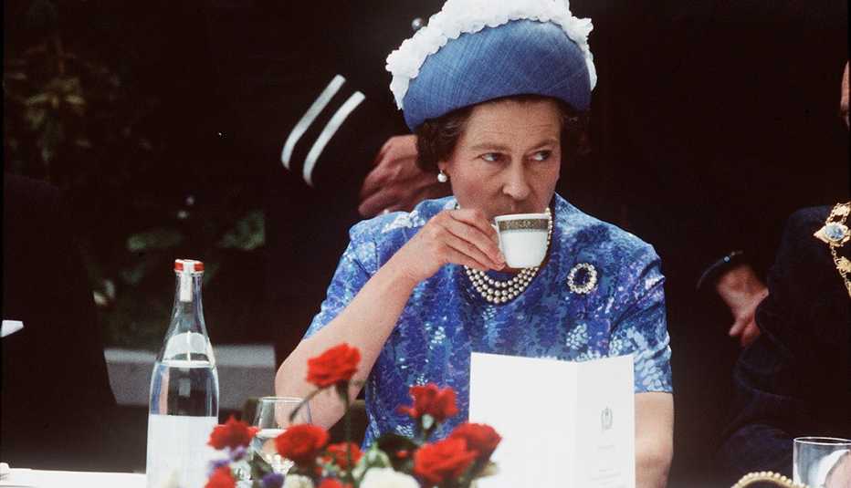 Queen Elizabeth ll drinking a cup of tea during a 1977 royal visit in Northern Ireland