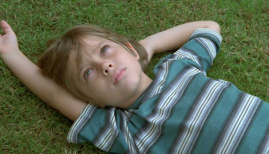 Ellar Coltrane lies on the grass in a scene from the film Boyhood