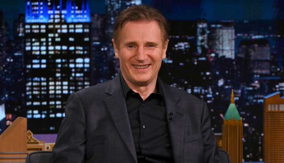 Liam Neeson smiling while making a guest appearance on The Tonight Show Starring Jimmy Fallon