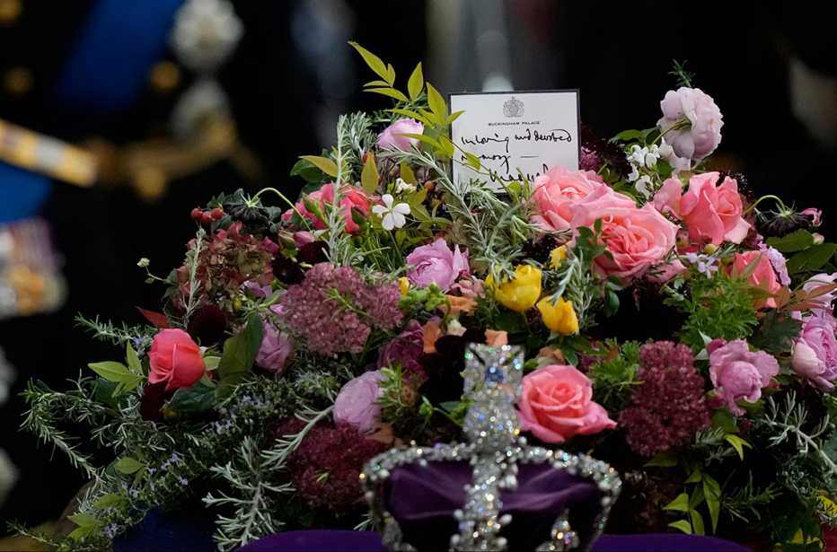 A note rests atop a flower arrangement on top of the coffin of Queen Elizabeth II