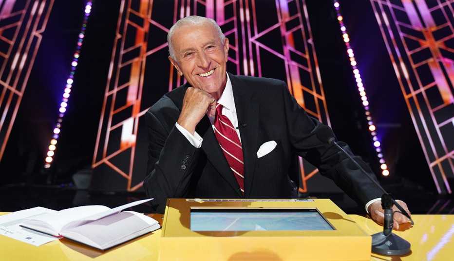 Len Goodman poses for a photo behind the judge's desk on Dancing With the Stars