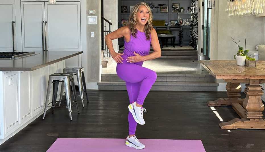denise austin performing an exercise on an exercise mat in her home