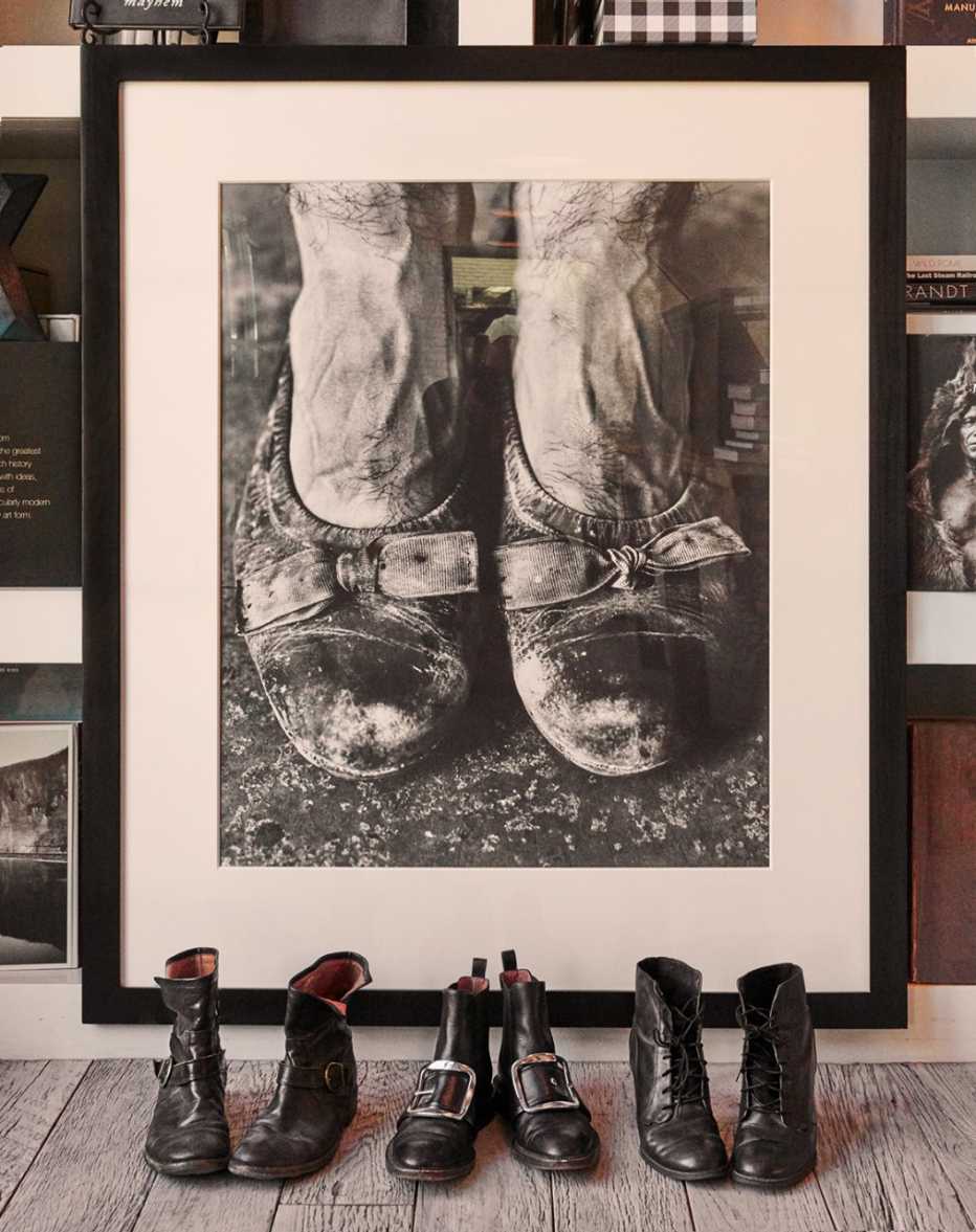 a few pairs of Keaton's boots in front of a framed photograph by Ruven Afanador