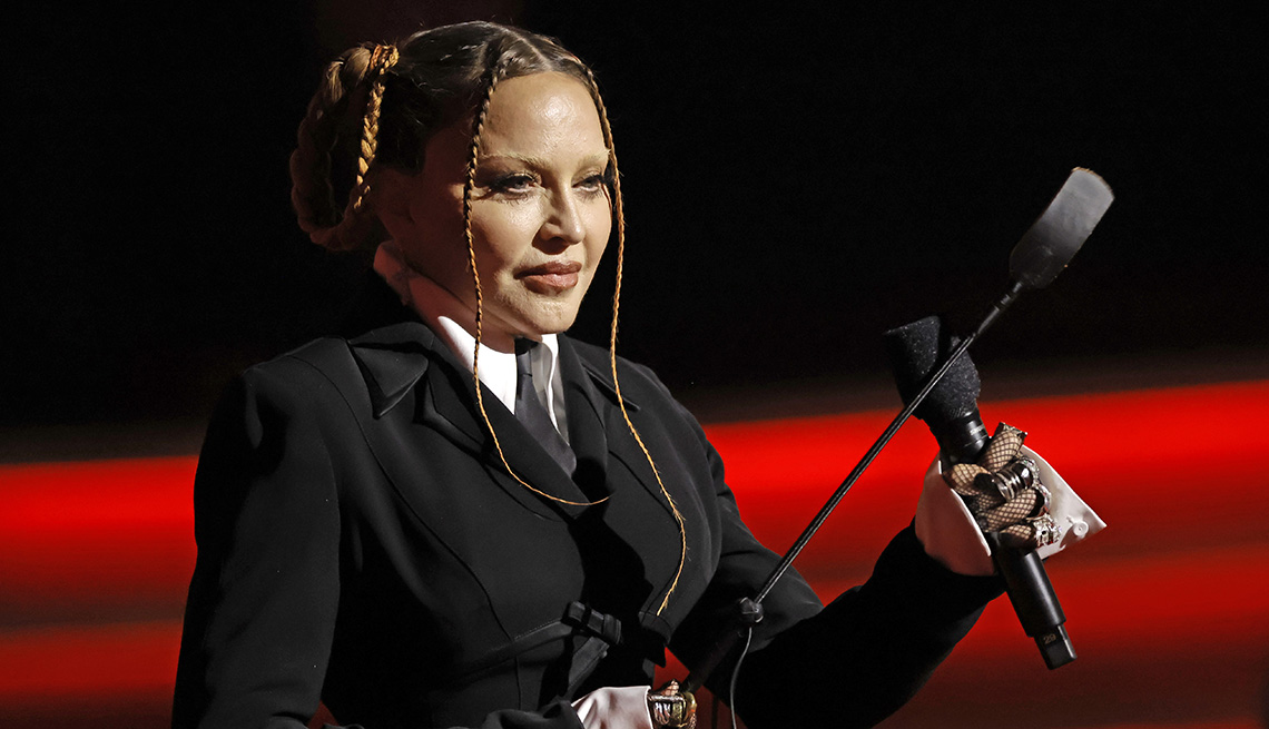 Madonna holding a microphone onstage as she presents an award at the 65th Grammy Awards