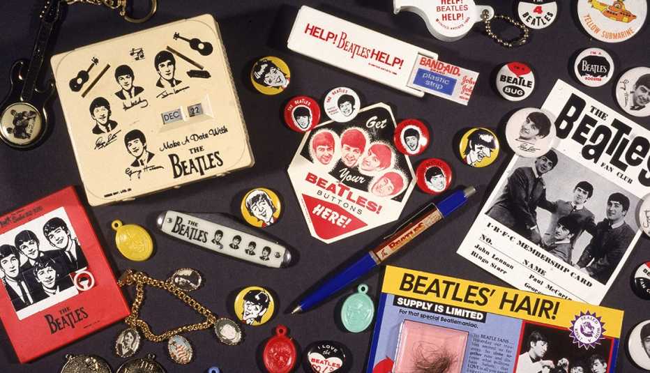 an assortment of beatles memorabilia including buttons flyers keychains and pens circa nineteen sixty five