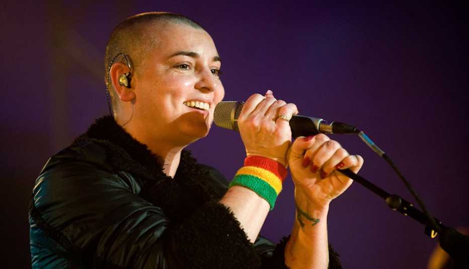 sinead o'connor smiles while standing in front of a microphone stand as she performs mencap's little noise sessions at saint john-at-hackney in london