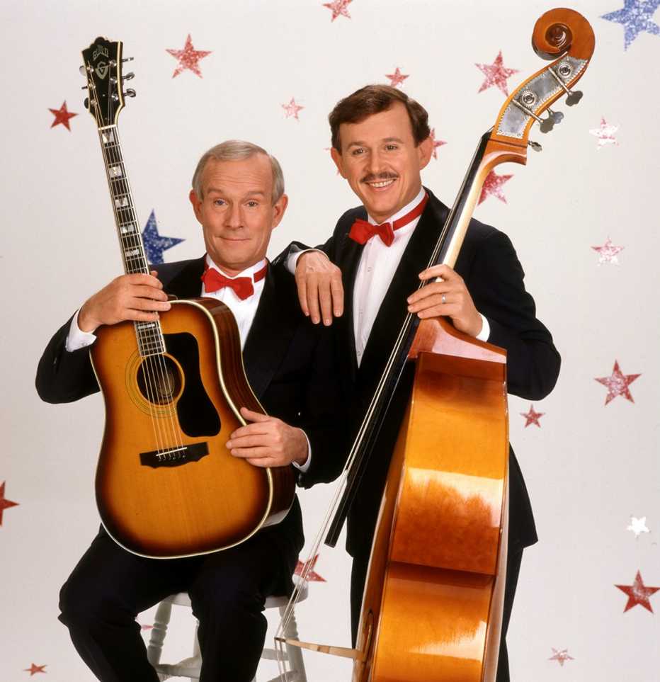 Tom Smothers and Dick Smothers holding their instruments for "The Smothers Brothers Comedy Hour 20th Reunion"