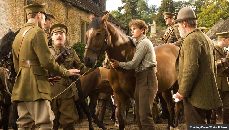 Albert (Jeremy Irvine, center) holds on to Joey defiantly while his father (Peter Mullan, right) looks on in this scene from DreamWorks Pictures' "War Horse".