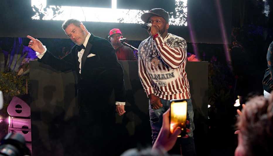 John Travolta on stage as  Singer 50 Cent performs.