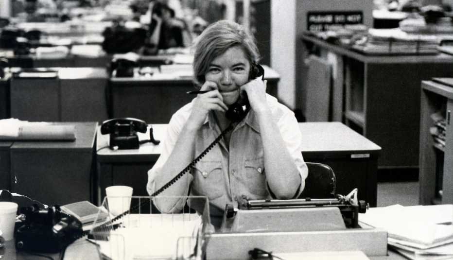 Molly Ivins sitting at a desk