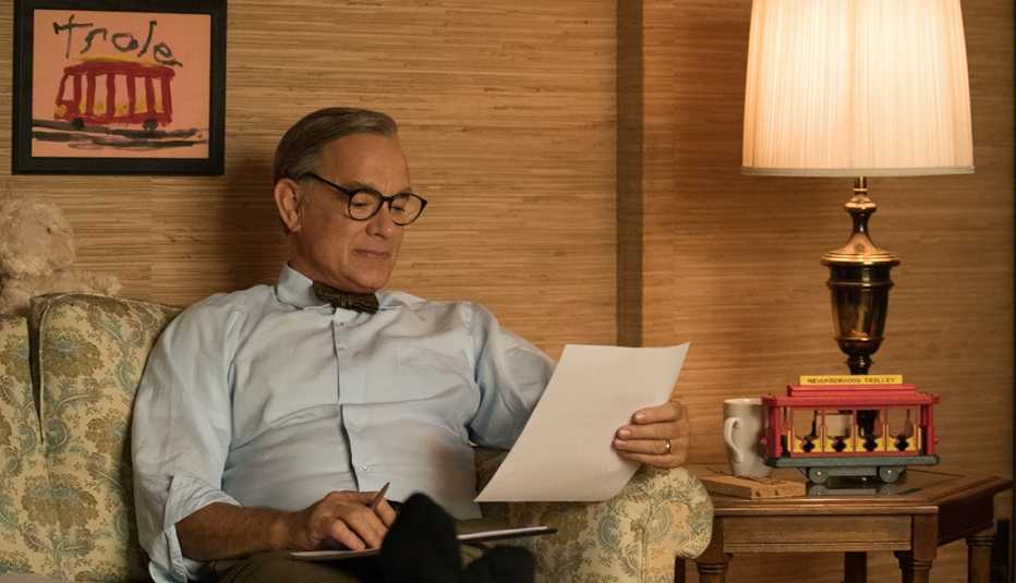 Tom Hanks as Mister Rogers reading a sheet of paper in the film A Beautiful Day in the Neighborhood