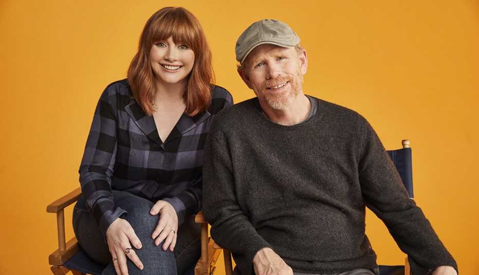 Bryce Dallas Howard and Ron Howard sitting in director's chairs next to each other