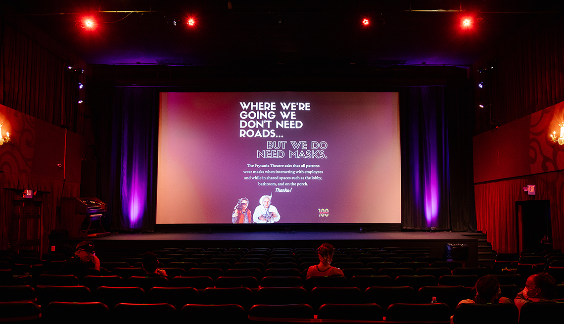 A public service health announcement is displayed on the screen at a nearly empty movie theater in New Orleans