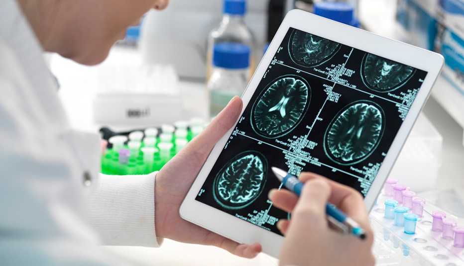A scientist viewing a patient's brain scan on digital tablet in laboratory