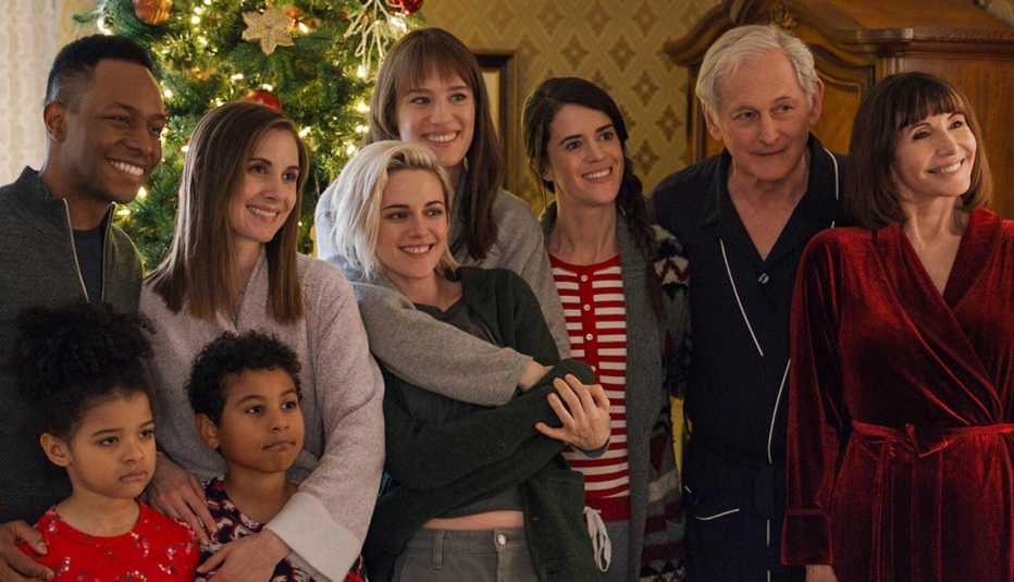 Burl Moseley, Alison Brie, Kristen Stewart, Mackenzie Davis, Mary Holland, Victor Garber and Mary Steenburgen together in front of a Christmas Tree in the film Happiest Season