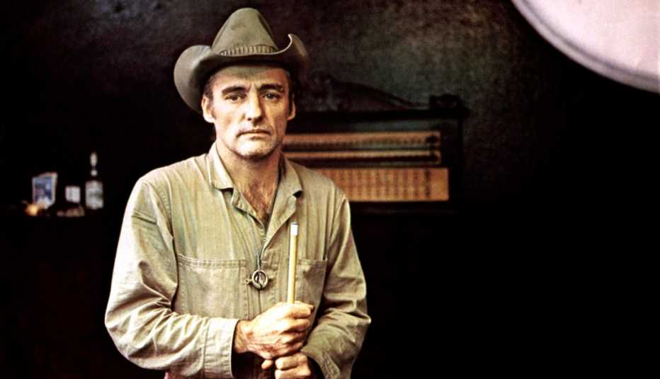 Dennis Hopper wearing a cowboy hat and holding a pool cue stick in the film The American Friend