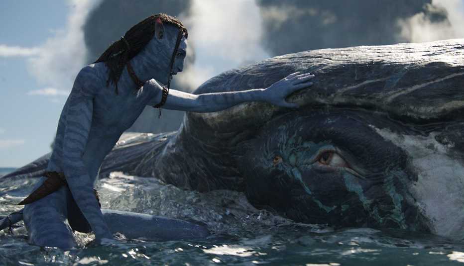 Jake Sully pets a sea creature in the film Avatar: The Way of Water
