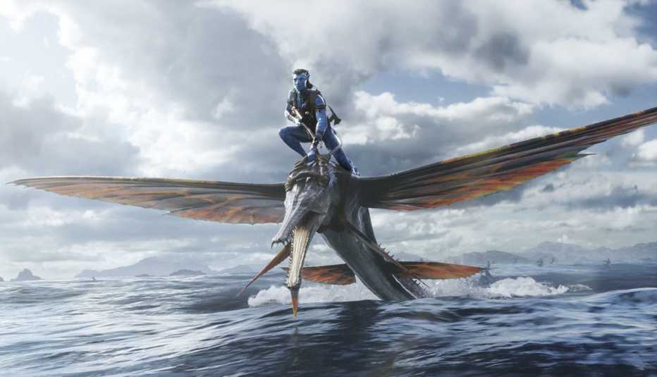 Jake Sully riding on a flying creature above a body of water in the film Avatar: The Way of Water