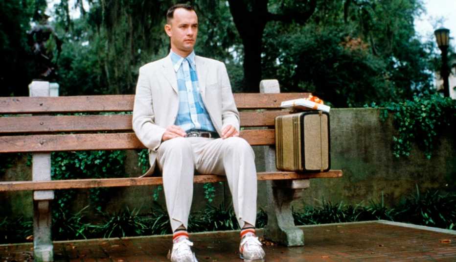 Tom Hanks sitting on a park bench at a bus stop in a scene from the film Forrest Gump