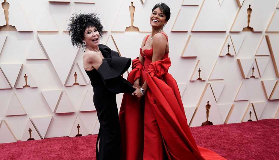 Rita Moreno and Ariana DeBose hold hands posing for a photo on the red carpet at the 94th Academy Awards