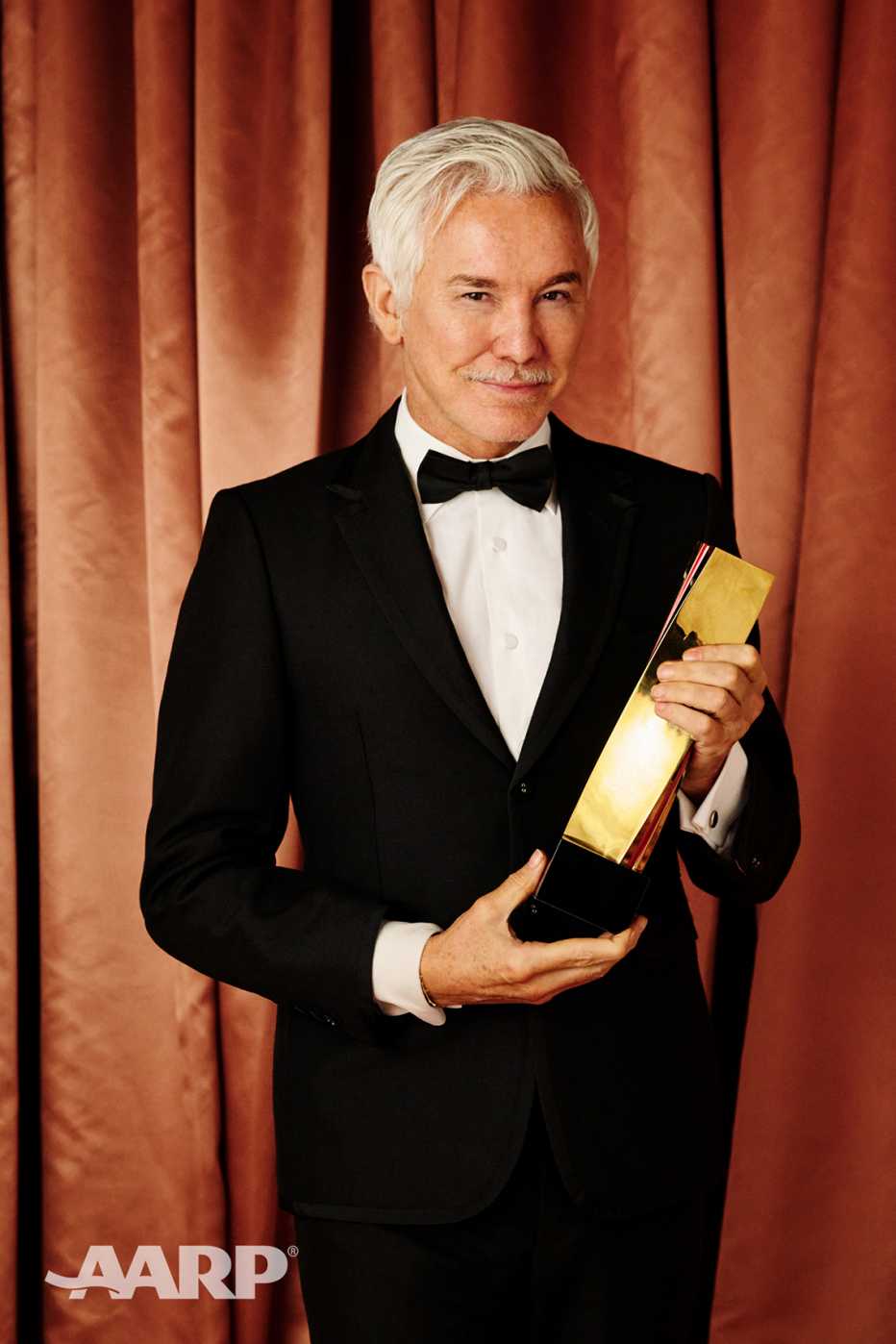 Baz Luhrmann holds his best director award at the AARP Movies for Grownups Awards