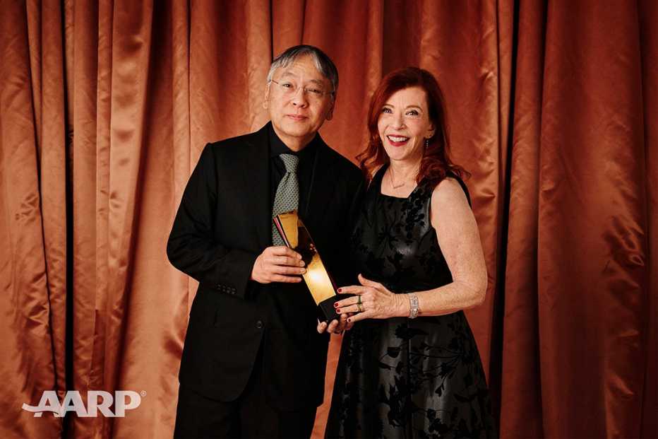 Kazuo Ishiguro and Susan Orlean holding the best screenwriter award at the AARP Movies for Grownups Awards