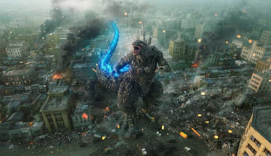 Godzilla roaring while standing in a debris of destruction in a city in "Godzilla Minus One."