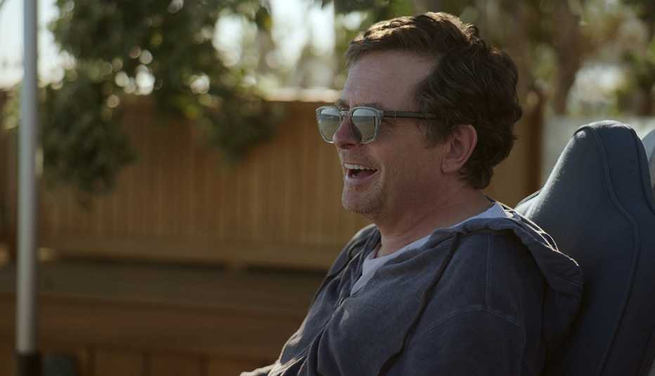 Michael J. Fox wearing glasses and smiling in the documentary Still: A Michael J. Fox Movie