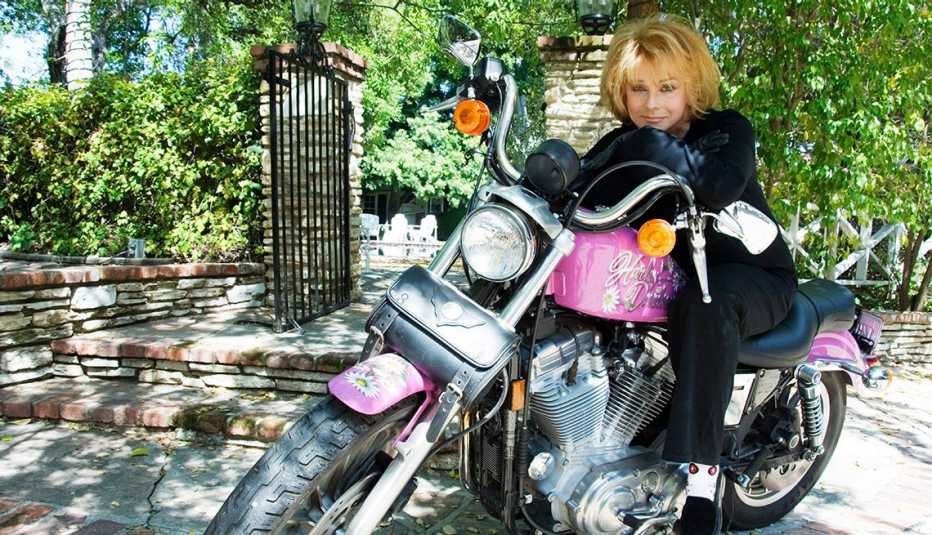 Ann Margret sitting on a pink and black Harley Davidson motorcycle for her album Born to Be Wild