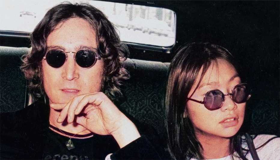 john lennon and may pang sitting inside the backseat of a vehicle