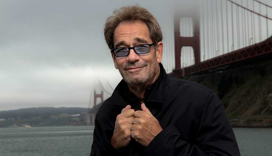 Singer Huey Lewis standing nearby San Francisco's Golden Gate Bridge on a foggy day