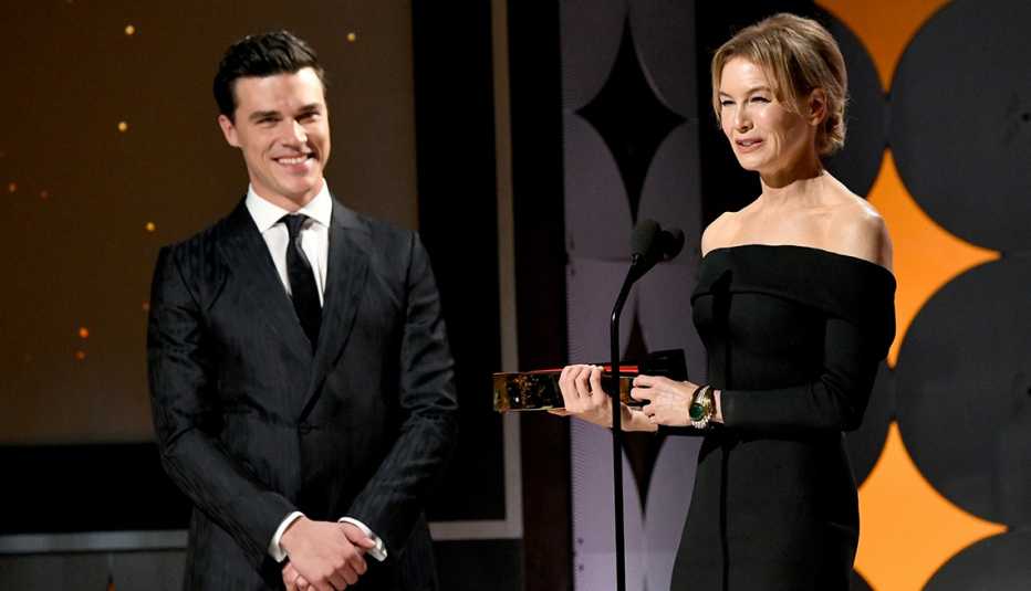 Finn Wittrock looks on as Renee Zellweger gives her speech after receiving the Best actress award at the Movies for Grownups Awards