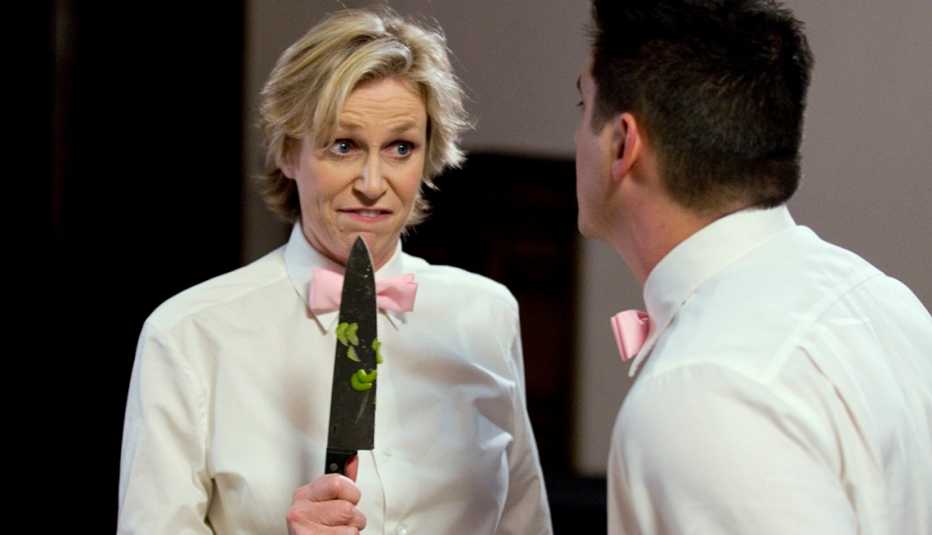 Jane Lynch holds a kitchen knife in a scene with Ken Marino in the TV series Party Down