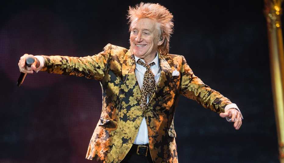 Rod Stewart extends his arms with a mic in one hand during a performance at The O2 Arena in London England