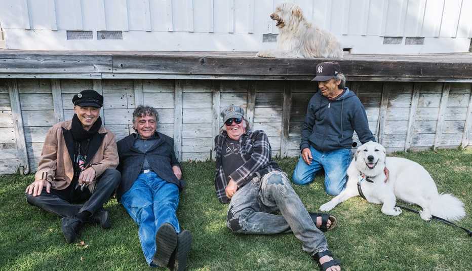 Neil Young lying on the grass with Crazy Horse and a couple of dogs
