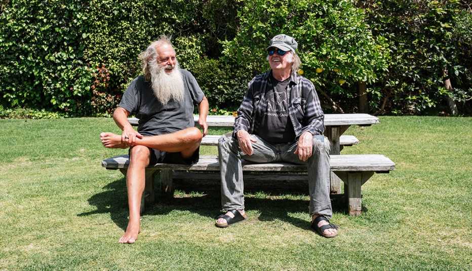 Rick Rubin and Neil Young sitting next to each other at a picnic table