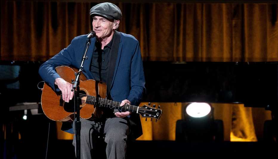 James Taylor playing his acoustic guitar onstage while performing during the Library of Congress Gershwin Prize for Popular Song ceremony in Washington DC honoring Joni Mitchell