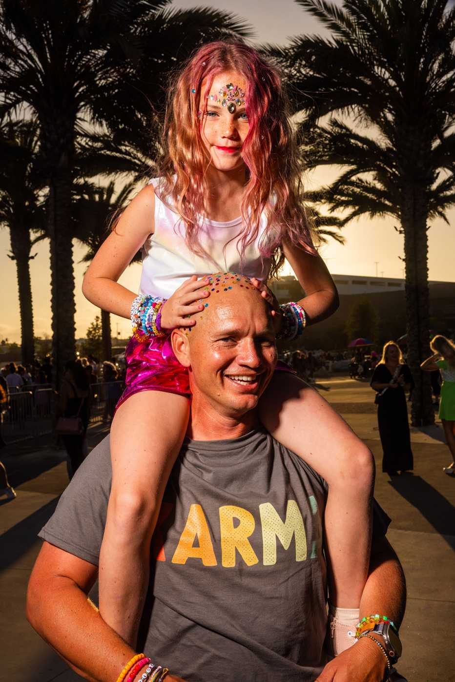 matt pobst with a shaved and bedazzled head posing with his daughter taylor on his shoulders
