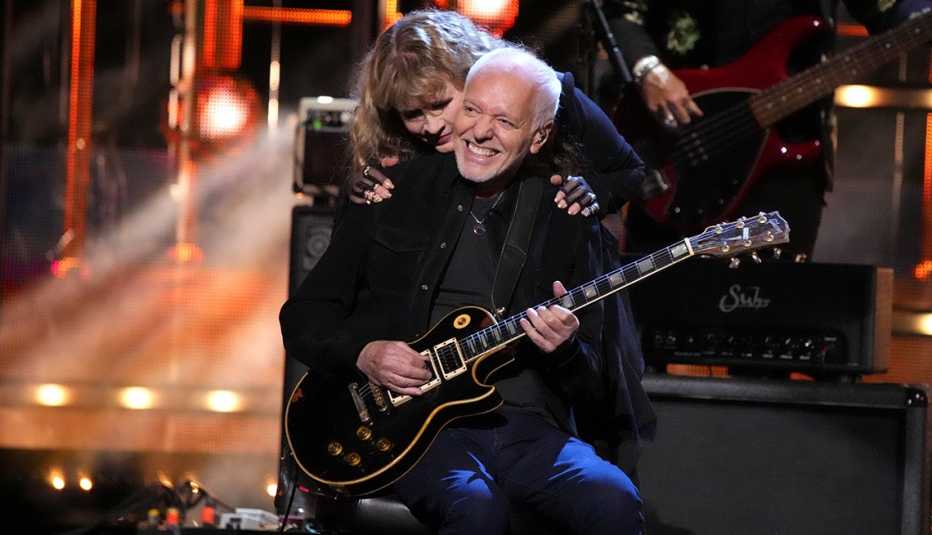 Stevie Nicks embraces Peter Frampton onstage at the 38th Annual Rock & Roll Hall of Fame Induction Ceremony.