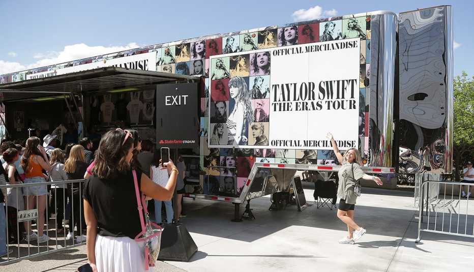 Fans taking a photo outside of the merchandise stand at State Farm Stadium in Arizona for the Taylor Swift The Eras Tour opening night