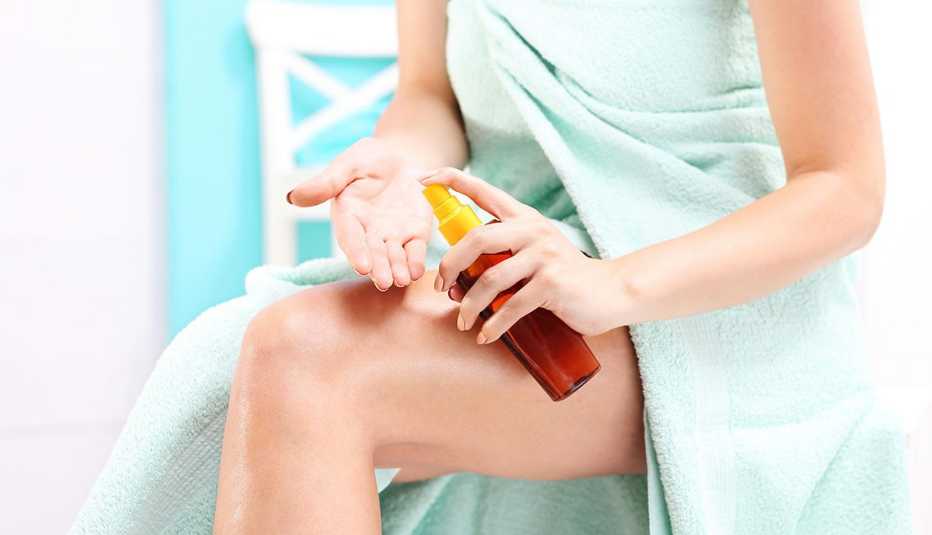 a woman moisturizing her skin after shower