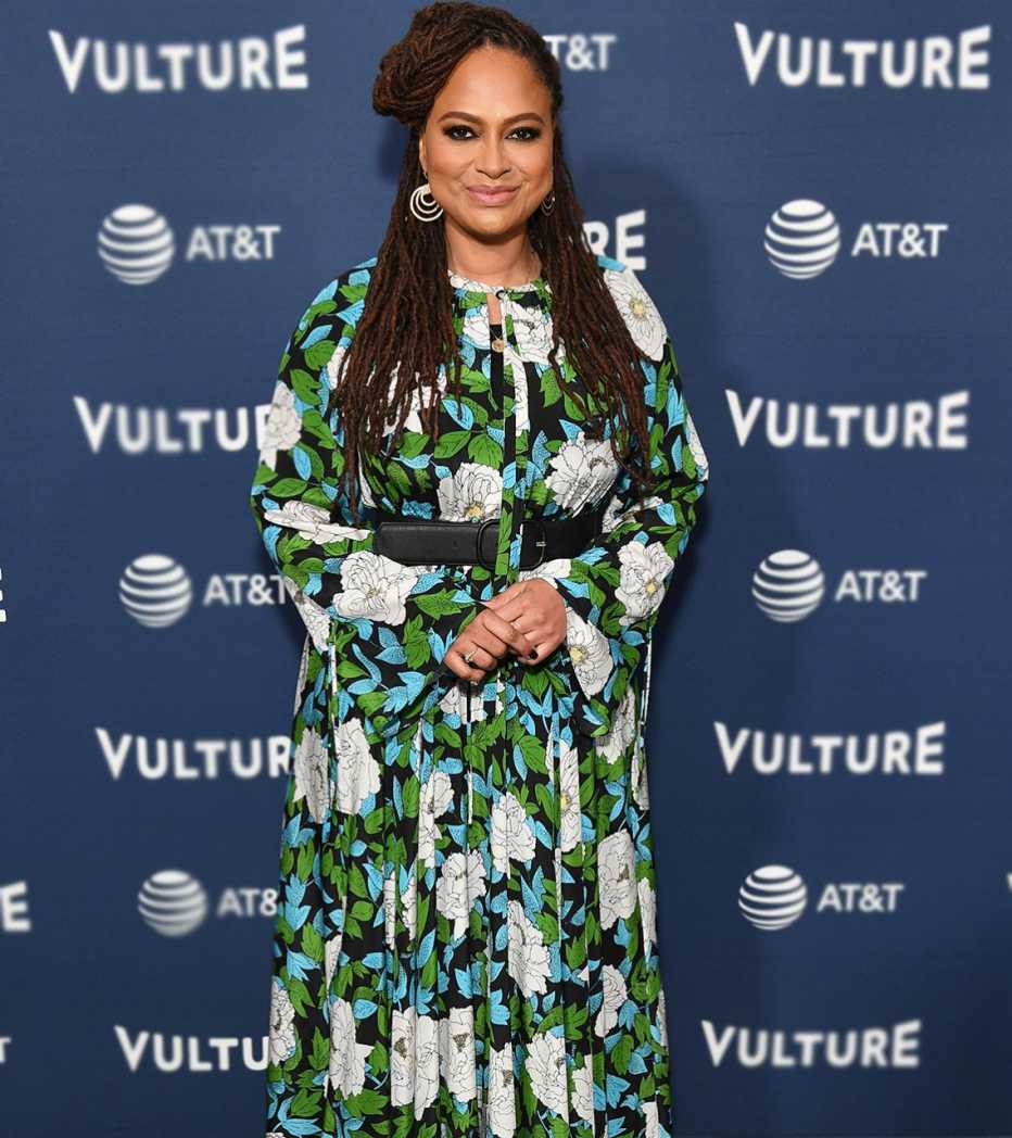 Ava DuVernay in a long flowing print dress with defined waist and bell sleeves.