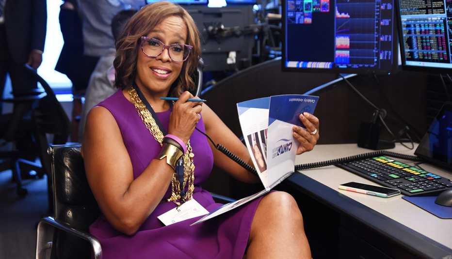 Gayle King event in a sleeveless purple dress, gold necklaces and purple multi-tone glasses