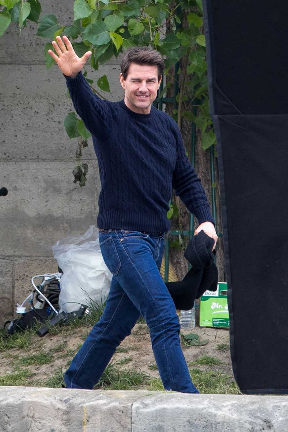 Tom Cruise in navy cabled crewneck and toned medium blue jeans