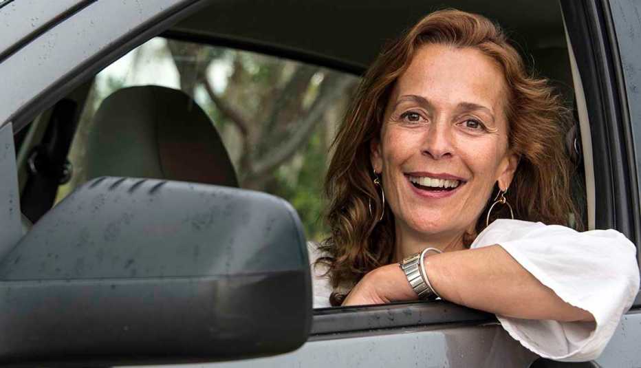 Mature woman smiling looking at the camera sitting in her car