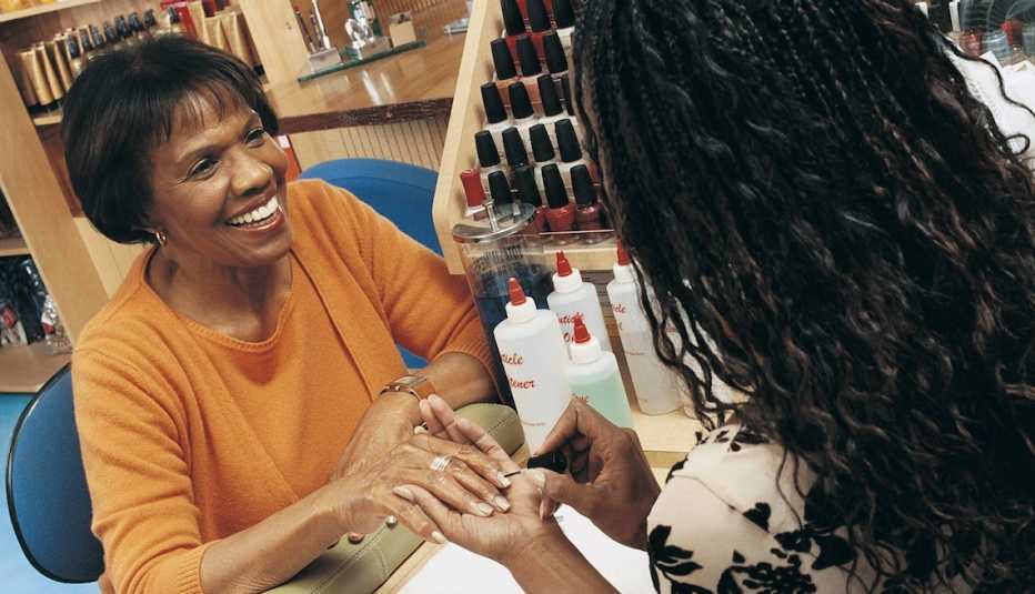 Smiling Woman Having Her Nails Manicured in a Beauty Salon