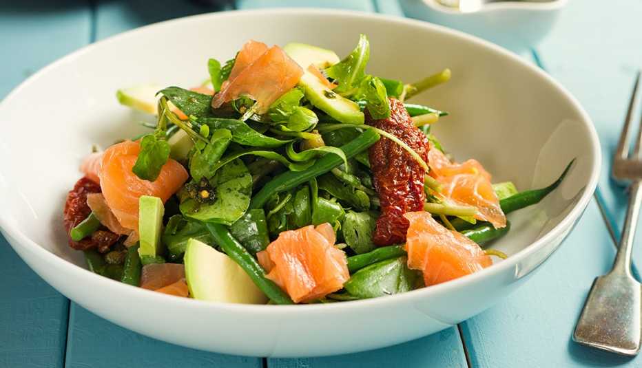 A healthy summer salad with smoked salmon, greens, tomatoes and avacado