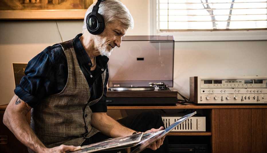 A man wearing headphones listening to vinyl records
