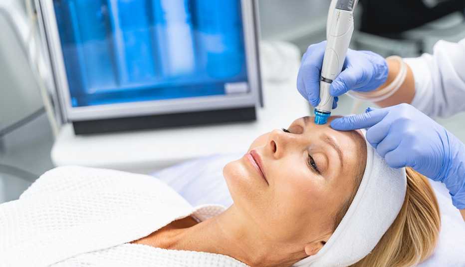 A woman lying down undergoing microdermabrasion treatment